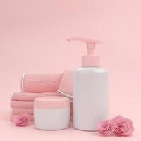 bottiglia della pompa per crema o profumo su sfondo rosa. foto