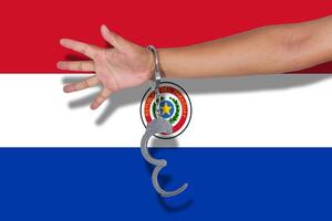 manette con la mano sulla bandiera del paraguay foto