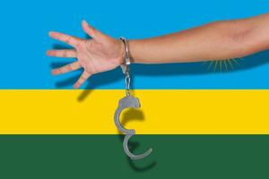 manette con la mano sulla bandiera del ruanda foto