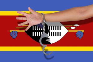 manette con la mano sulla bandiera dello swaziland foto