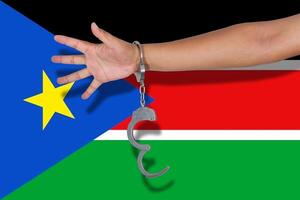 manette con la mano sulla bandiera del sud sudan foto