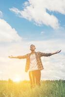 libertà il giovane adolescente che allunga le braccia verso il cielo si diverte e felice con l'aria fresca nei prati. foto