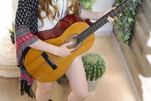 il minerale femminile tiene una chitarra classica a sette corde. foto