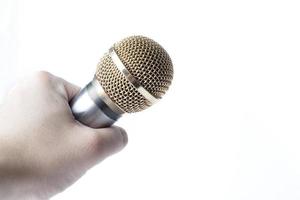 la mano di un uomo tiene un microfono su uno sfondo bianco. foto
