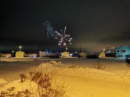 fuochi d'artificio di capodanno nel villaggio di cottage in una notte d'inverno foto