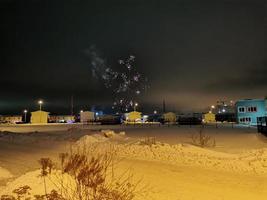 fuochi d'artificio di capodanno nel villaggio di cottage in una notte d'inverno foto