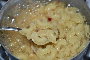 cuocere la pasta in una pentola in cucina foto