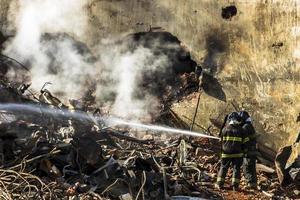 vigile del fuoco brasiliano combatte le fiamme tra le macerie dove un edificio di 24 piani è crollato dopo un incendio foto