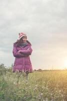 giovane donna stava giocando in un campo di fiori nell'aria invernale. foto