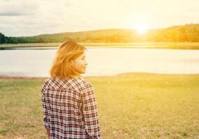 giovane donna hipster a piedi al lago godersi la natura e l'aria fresca. foto