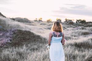 donna triste che cammina da sola nei prati, solitudine foto