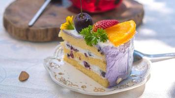 primo piano fetta torta di frutta di compleanno nel piatto viola deliziosa crema a strati