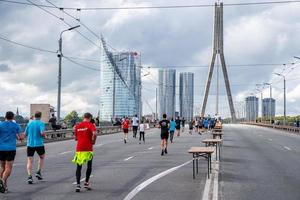 corridori che attraversano le strade di riga durante la maratona di tet riga. foto