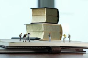 concetto di idea creativa - fotografo in miniatura con libro d'oro vintage su quaderno di carta aperto foto