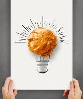 lampadina disegnata a mano con palla di carta stropicciata su poster di carta come concetto creativo foto
