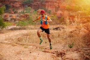 un corridore uomo di trail e piedi d'atleta che indossa scarpe sportive per il trail running nella foresta foto