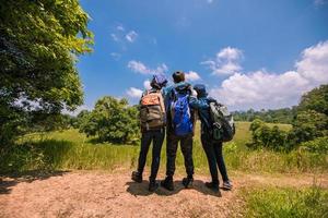 gruppo asiatico di giovani che fanno escursioni con gli amici zaini camminano insieme e guardano la mappa e prendono la macchina fotografica lungo la strada e sembrano felici, tempo di relax durante il concetto di vacanza viaggio foto