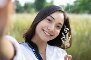 donne asiatiche sorriso felice che scatta foto e selfie durante il relax al prato e all'erba