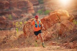 un uomo corridore di sentiero. e piedi d'atleta che indossano scarpe sportive per il trail running in montagna foto