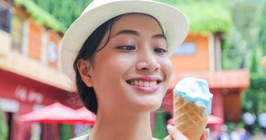 bella femmina che tiene e mangia il gelato durante le vacanze estive foto