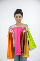 la bella ragazza delle donne asiatiche tiene in mano le borse della spesa e sorride foto