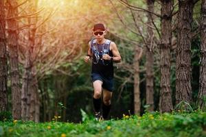 un corridore uomo di trail e piedi d'atleta che indossa scarpe sportive per il trail running nella foresta foto