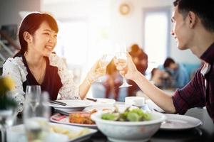 giovane coppia asiatica godendo di una cena romantica drink serali seduti al tavolo da pranzo in cucina insieme foto