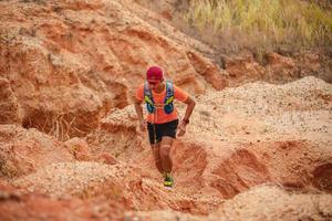 un uomo corridore di sentiero. e piedi d'atleta che indossano scarpe sportive per il trail running in montagna foto