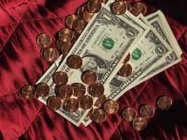 banconote e monete in dollari, stati uniti su sfondo di velluto rosso foto