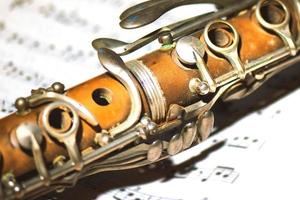 piccolo dettaglio di un vecchio clarinetto su spartito musicale foto