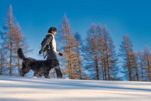 ragazza che cammina con il suo cane nella neve foto