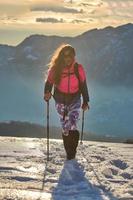 ragazza cammina nella neve durante un trekking alpino foto