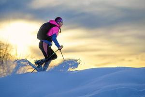 tanta neve fresca che si muove dove passa una ragazza con le ciaspole foto