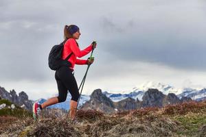 donna sportiva durante un trekking in montagna da sola foto