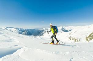 uno scialpinista si arrampica con la pelle di foca sotto gli sci foto