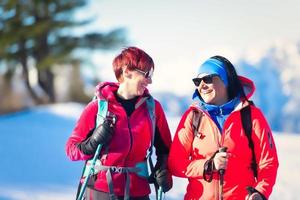 coppia felice della giovane donna durante un'escursione sulla neve foto