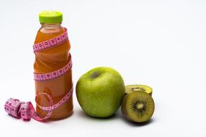 succo di frutta in bottiglia, mela e kiwi su sfondo bianco. foto