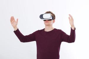 giovane eccitato in un auricolare vr, occhiali. realtà virtuale isolata su sfondo bianco. copia spazio e simula foto