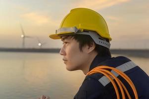 un ingegnere maschio che indossa un casco protettivo al tramonto. foto