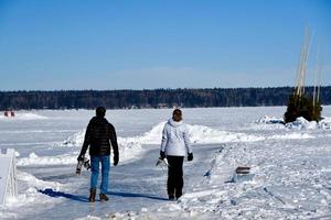 inverno a manitoba - una coppia che porta i pattini cammina su un lago ghiacciato foto