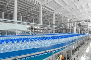 tashkent, uzbekistan - 7 giugno 2016 - stabilimento per la produzione di bottiglie di plastica. bottiglie di plastica su un nastro trasportatore. riempimento di acqua in bottiglia foto