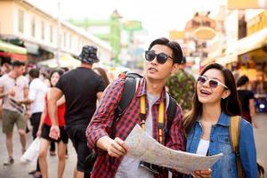 turisti asiatici delle coppie che viaggiano a khao san road bangkok tailandia durante le vacanze estive foto