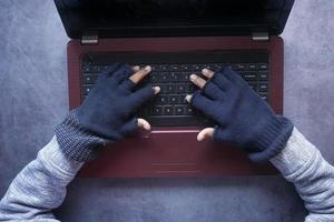 mano di hacker che ruba dati dal laptop dall'alto verso il basso foto