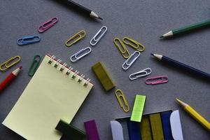 matite blocco note e graffette sulla scrivania dell'ufficio foto