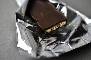 caramelle al cioccolato in un involucro su sfondo grigio foto