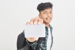 giovane indiano che mostra carta di debito o di credito su sfondo bianco. foto