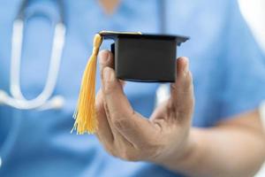 lo studio medico asiatico impara con il cappello del divario di laurea nel reparto ospedaliero, concetto di medicina intelligente per l'educazione del genio brillante. foto