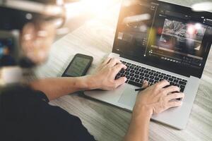 mano dell'uomo d'affari che partecipa alla videoconferenza con un computer portatile e un tablet alla scrivania in ufficio foto