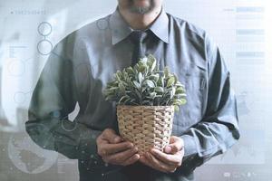 uomo d'affari di successo che tiene pianta del vaso, albero, vista frontale, effetto filtro foto