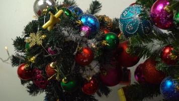 concetto di stagione dei saluti. Impostazione a mano di ornamenti su un albero di natale con luce decorativa foto